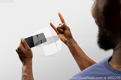 Image of Close up male hands holding smartphone with blank screen during online watching of popular sport matches and championships all around the world. Copyspace for ad