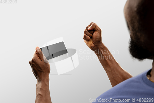 Image of Close up male hands holding smartphone with blank screen during online watching of popular sport matches and championships all around the world. Copyspace for ad