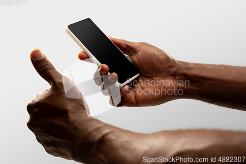 Image of Close up male hands holding smartphone with blank screen during online watching of popular sport matches and championships all around the world. Copyspace for ad