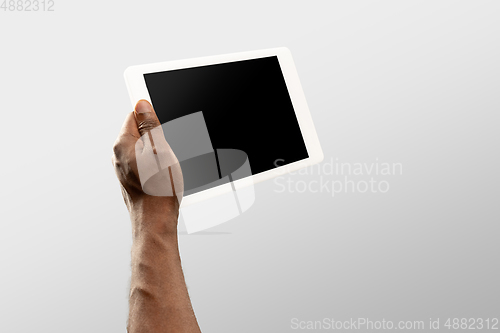 Image of Close up male hands holding tablet with blank screen during online watching of popular sport matches and championships all around the world. Copyspace for ad