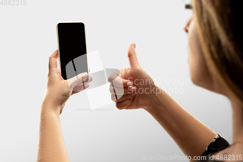 Image of Close up female hands holding smartphone with blank screen during online watching of popular sport matches and championships all around the world. Copyspace for ad