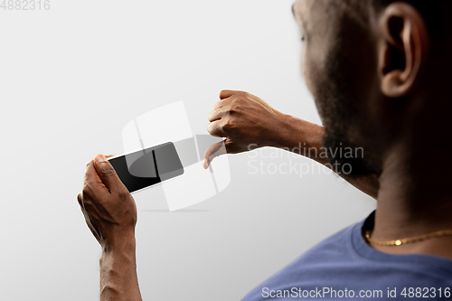 Image of Close up male hands holding smartphone with blank screen during online watching of popular sport matches and championships all around the world. Copyspace for ad