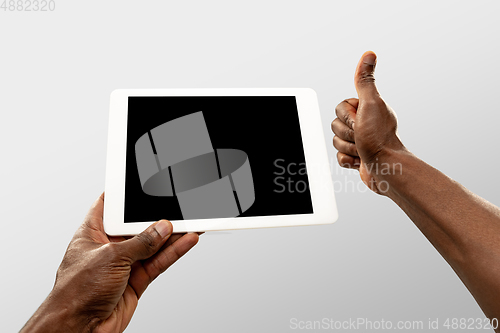 Image of Close up male hands holding tablet with blank screen during online watching of popular sport matches and championships all around the world. Copyspace for ad