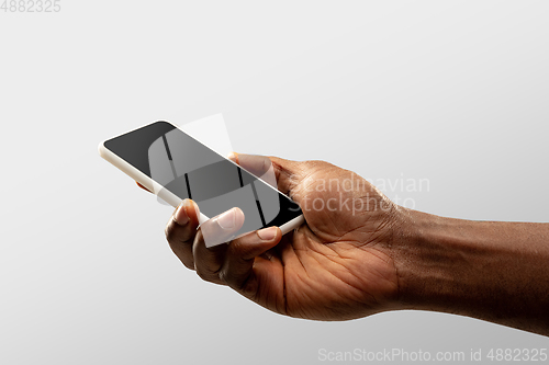 Image of Close up male hands holding smartphone with blank screen during online watching of popular sport matches and championships all around the world. Copyspace for ad