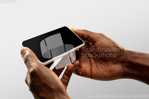 Image of Close up male hands holding smartphone with blank screen during online watching of popular sport matches and championships all around the world. Copyspace for ad