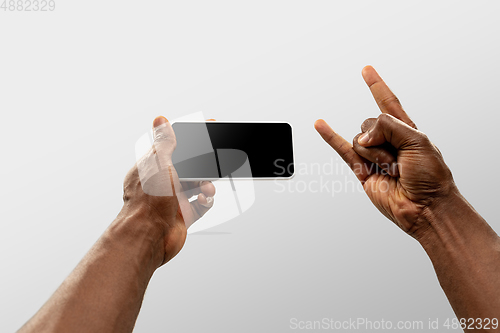 Image of Close up male hands holding smartphone with blank screen during online watching of popular sport matches and championships all around the world. Copyspace for ad