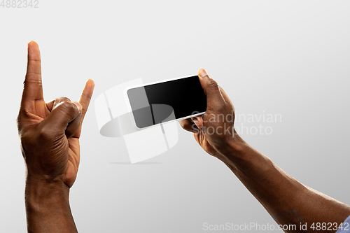 Image of Close up male hands holding smartphone with blank screen during online watching of popular sport matches and championships all around the world. Copyspace for ad