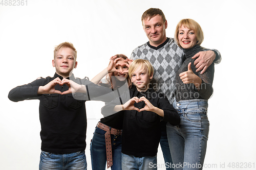 Image of Portrait of an ordinary large family, teenagers show a gesture in the shape of a heart and joyfully look into the frame
