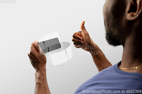 Image of Close up male hands holding smartphone with blank screen during online watching of popular sport matches and championships all around the world. Copyspace for ad