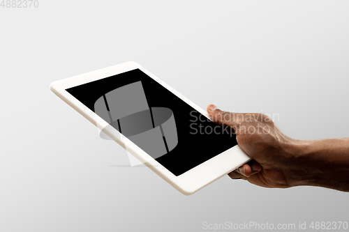 Image of Close up male hands holding tablet with blank screen during online watching of popular sport matches and championships all around the world. Copyspace for ad