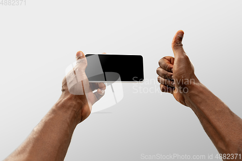 Image of Close up male hands holding smartphone with blank screen during online watching of popular sport matches and championships all around the world. Copyspace for ad
