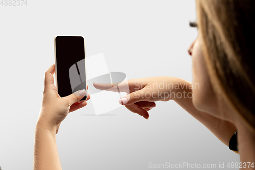 Image of Close up female hands holding smartphone with blank screen during online watching of popular sport matches and championships all around the world. Copyspace for ad