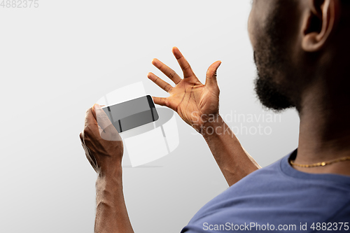 Image of Close up male hands holding smartphone with blank screen during online watching of popular sport matches and championships all around the world. Copyspace for ad