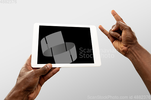 Image of Close up male hands holding tablet with blank screen during online watching of popular sport matches and championships all around the world. Copyspace for ad