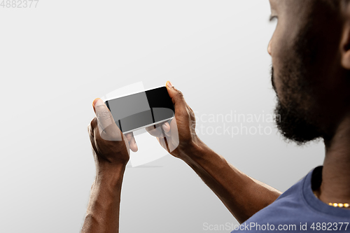 Image of Close up male hands holding smartphone with blank screen during online watching of popular sport matches and championships all around the world. Copyspace for ad