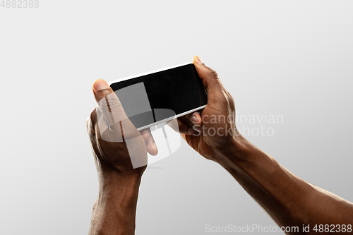 Image of Close up male hands holding smartphone with blank screen during online watching of popular sport matches and championships all around the world. Copyspace for ad