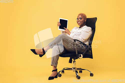 Image of Young african-american woman in casual wear on yellow background. Bodypositive female character, plus size businesswoman