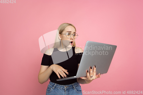 Image of Portrait of young caucasian woman with bright emotions on coral pink studio background