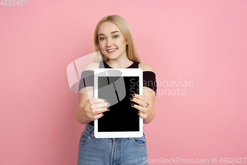 Image of Portrait of young caucasian woman with bright emotions on coral pink studio background