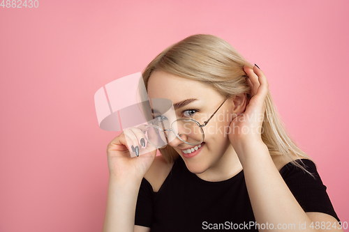 Image of Portrait of young caucasian woman with bright emotions on coral pink studio background