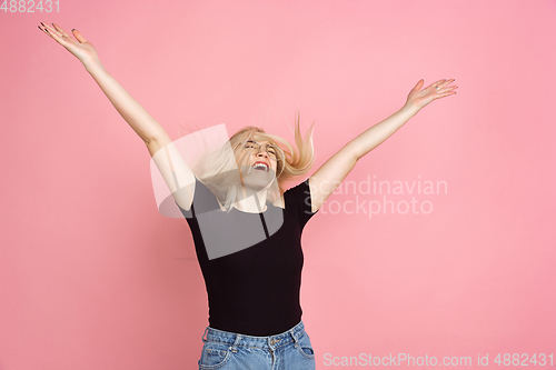 Image of Portrait of young caucasian woman with bright emotions on coral pink studio background