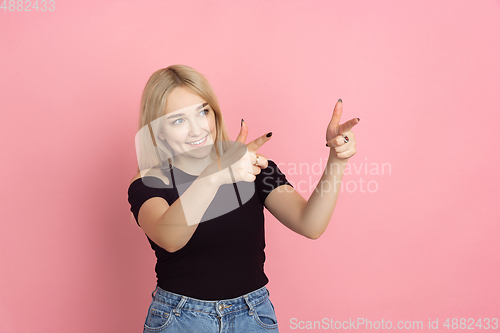 Image of Portrait of young caucasian woman with bright emotions on coral pink studio background