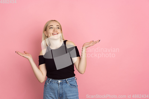 Image of Portrait of young caucasian woman with bright emotions on coral pink studio background
