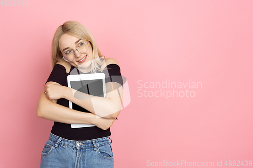 Image of Portrait of young caucasian woman with bright emotions on coral pink studio background