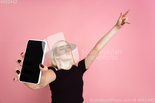 Image of Portrait of young caucasian woman with bright emotions on coral pink studio background