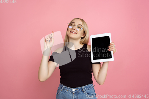 Image of Portrait of young caucasian woman with bright emotions on coral pink studio background