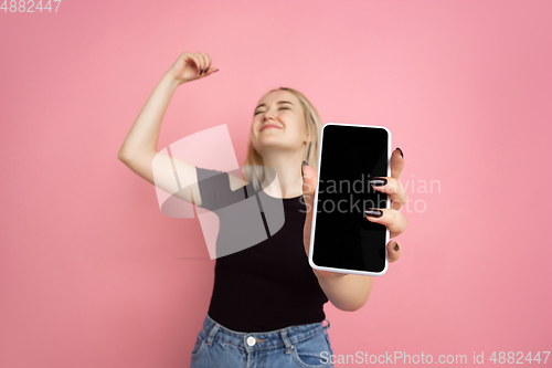 Image of Portrait of young caucasian woman with bright emotions on coral pink studio background