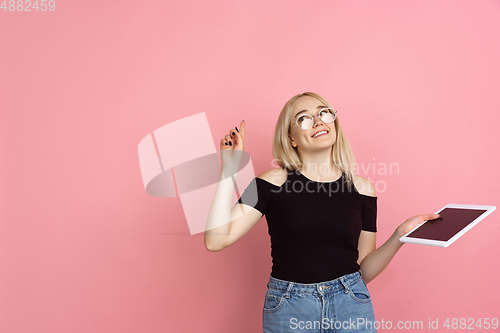 Image of Portrait of young caucasian woman with bright emotions on coral pink studio background