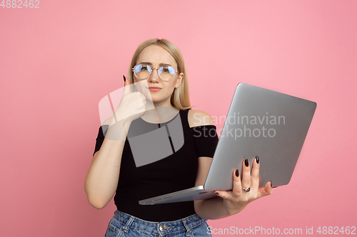 Image of Portrait of young caucasian woman with bright emotions on coral pink studio background