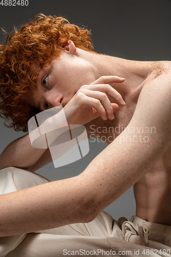 Image of Portrait of beautiful redhead man isolated on grey studio background. Concept of beauty, skin care, fashion and style