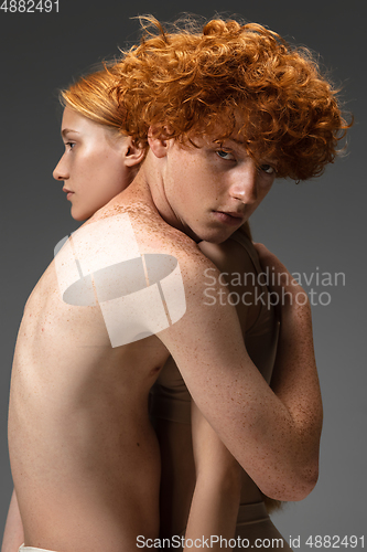 Image of Portrait of beautiful redhead couple isolated on grey studio background. Concept of beauty, skin care, fashion and style