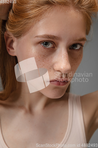 Image of Portrait of beautiful redhead woman isolated on grey studio background. Concept of beauty, skin care, fashion and style