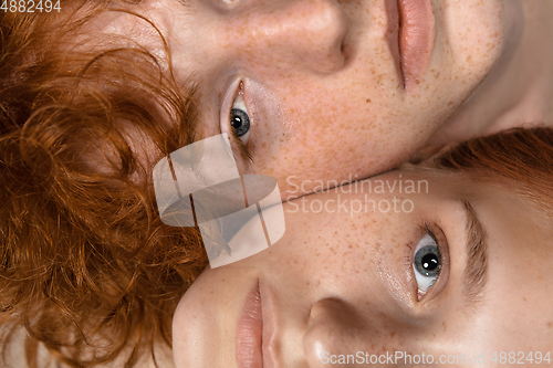 Image of Portrait of beautiful redhead couple isolated on grey studio background. Concept of beauty, skin care, fashion and style