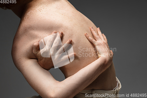 Image of Portrait of beautiful redhead man isolated on grey studio background. Concept of beauty, skin care, fashion and style