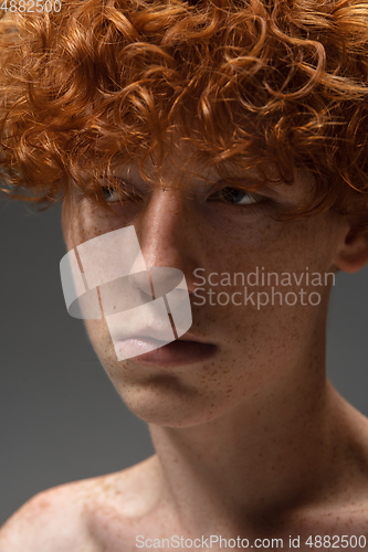 Image of Portrait of beautiful redhead man isolated on grey studio background. Concept of beauty, skin care, fashion and style