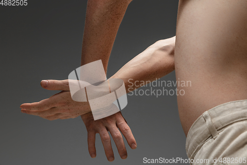 Image of Portrait of beautiful redhead man isolated on grey studio background. Concept of beauty, skin care, fashion and style