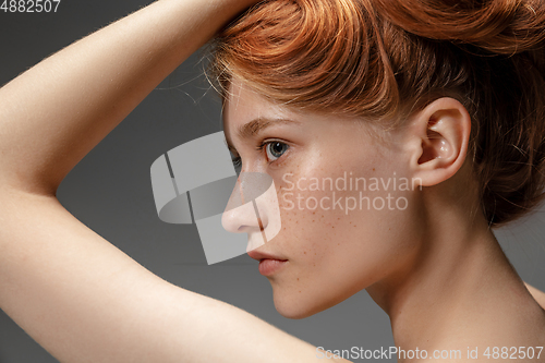 Image of Portrait of beautiful redhead woman isolated on grey studio background. Concept of beauty, skin care, fashion and style