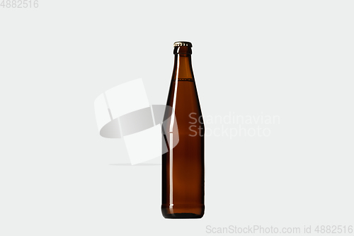 Image of Empty golden colored beer bottle. Isolated on white studio background