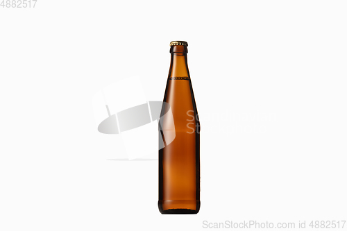 Image of Empty golden colored beer bottle. Isolated on white studio background