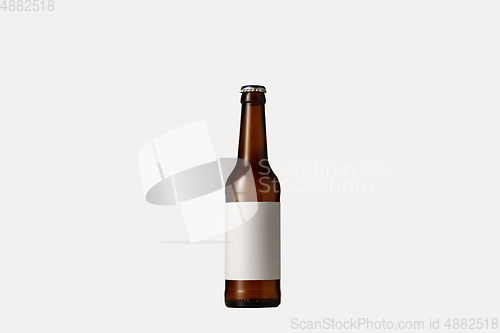 Image of Empty golden colored beer bottle. Isolated on white studio background