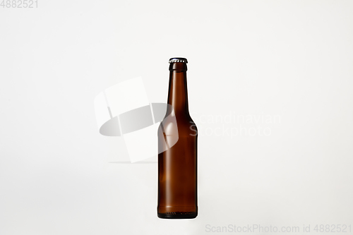 Image of Empty golden colored beer bottle. Isolated on white studio background