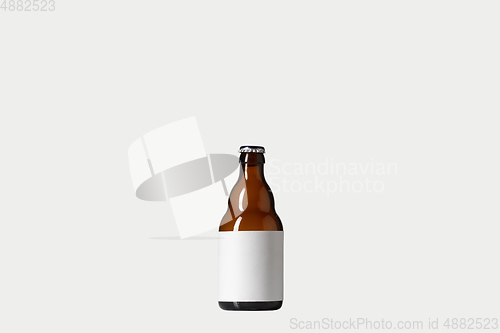 Image of Empty golden colored beer bottle. Isolated on white studio background