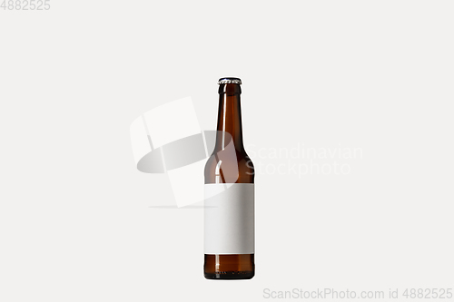 Image of Empty golden colored beer bottle. Isolated on white studio background