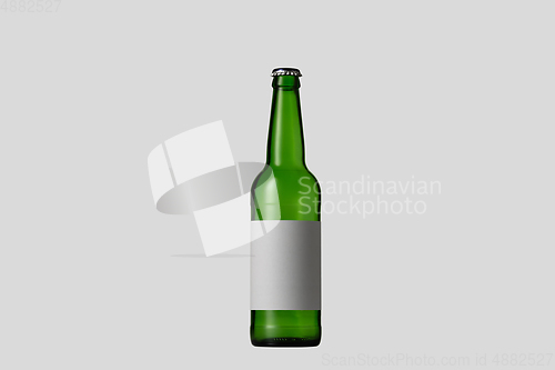 Image of Empty green colored beer bottle. Isolated on white studio background