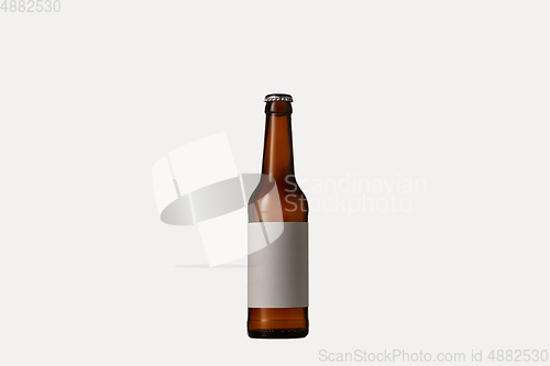 Image of Empty golden colored beer bottle. Isolated on white studio background