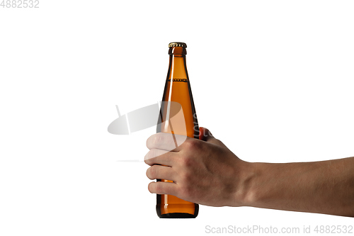 Image of Empty golden colored beer bottle in male hand. Isolated on white studio background